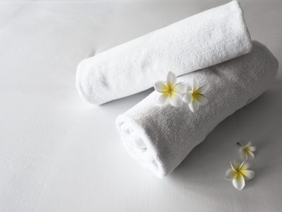 rolled-up-clean-towels-bed-min